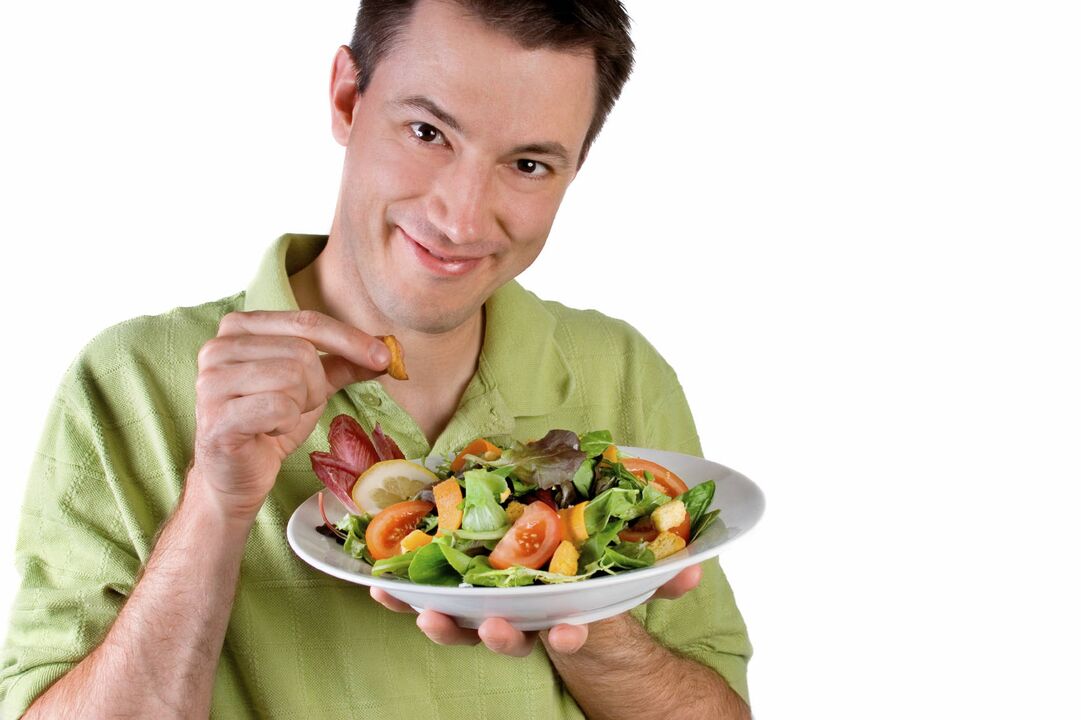 Mann isst Gemüsesalat für Potenz
